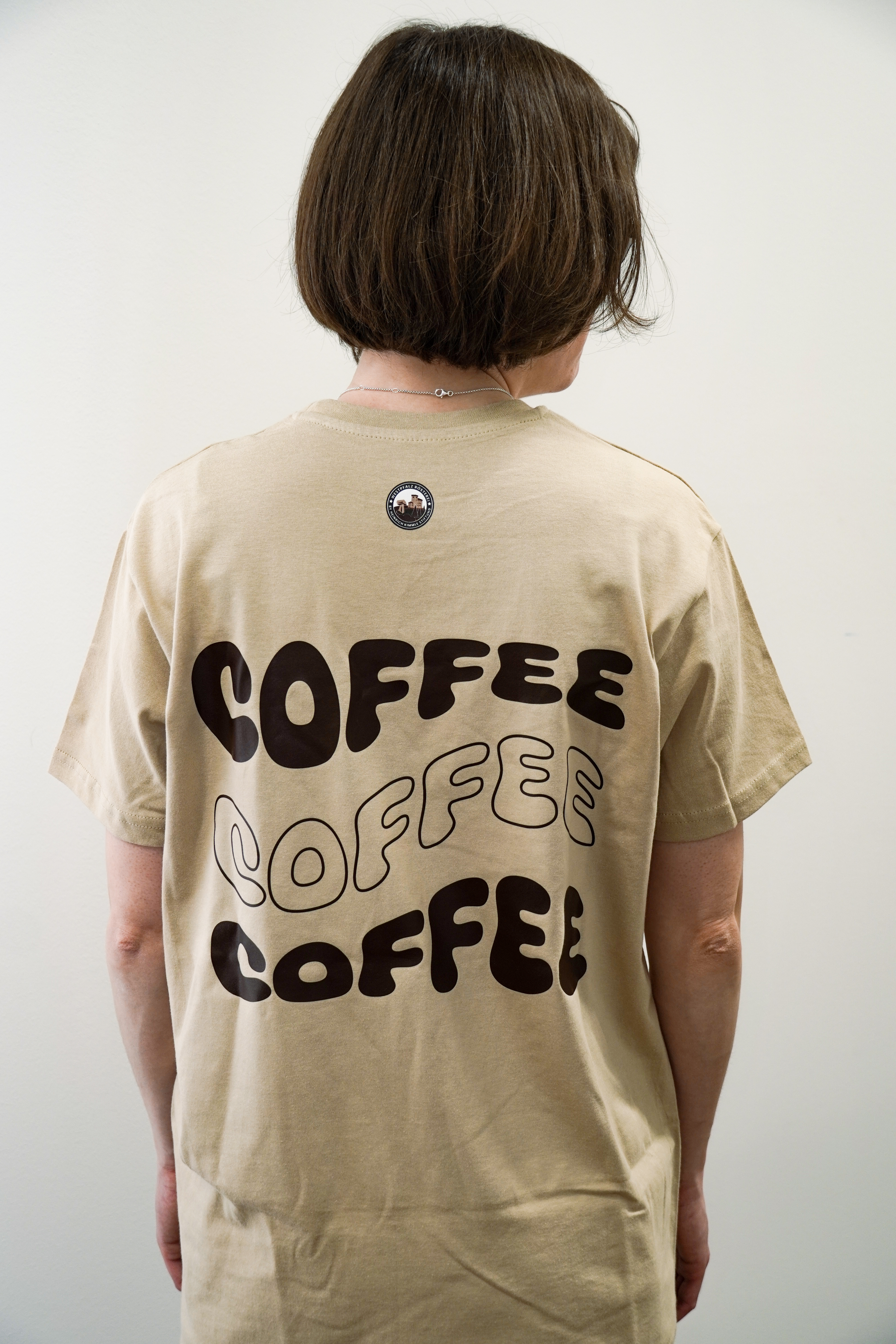 Foto von Frau mit Westpfalzrösterei T-Shirt beige mit Coffee Aufdruck