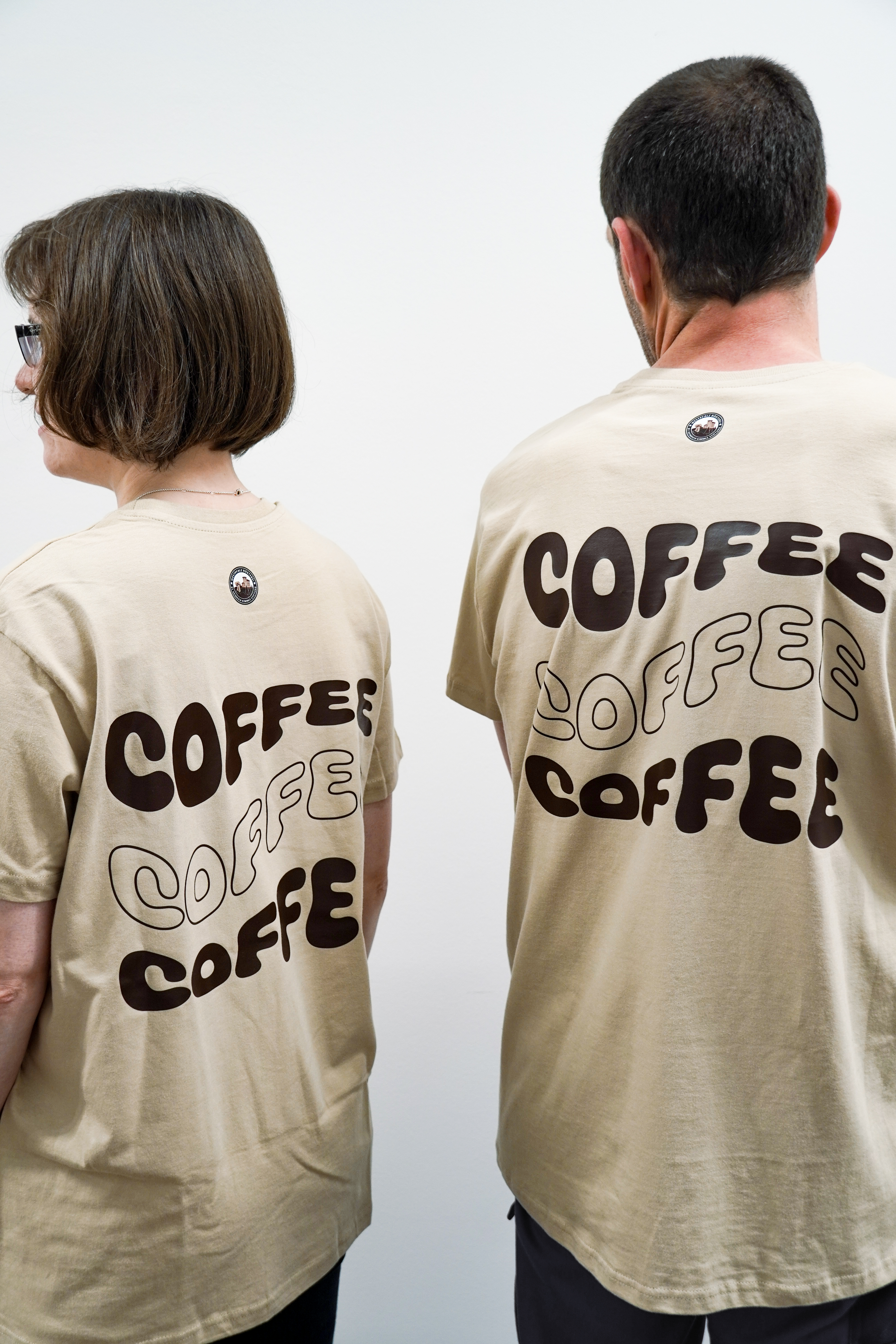 Foto von Frau und Mann mit Westpfalzrösterei T-Shirt beige mit Coffee Aufdruck