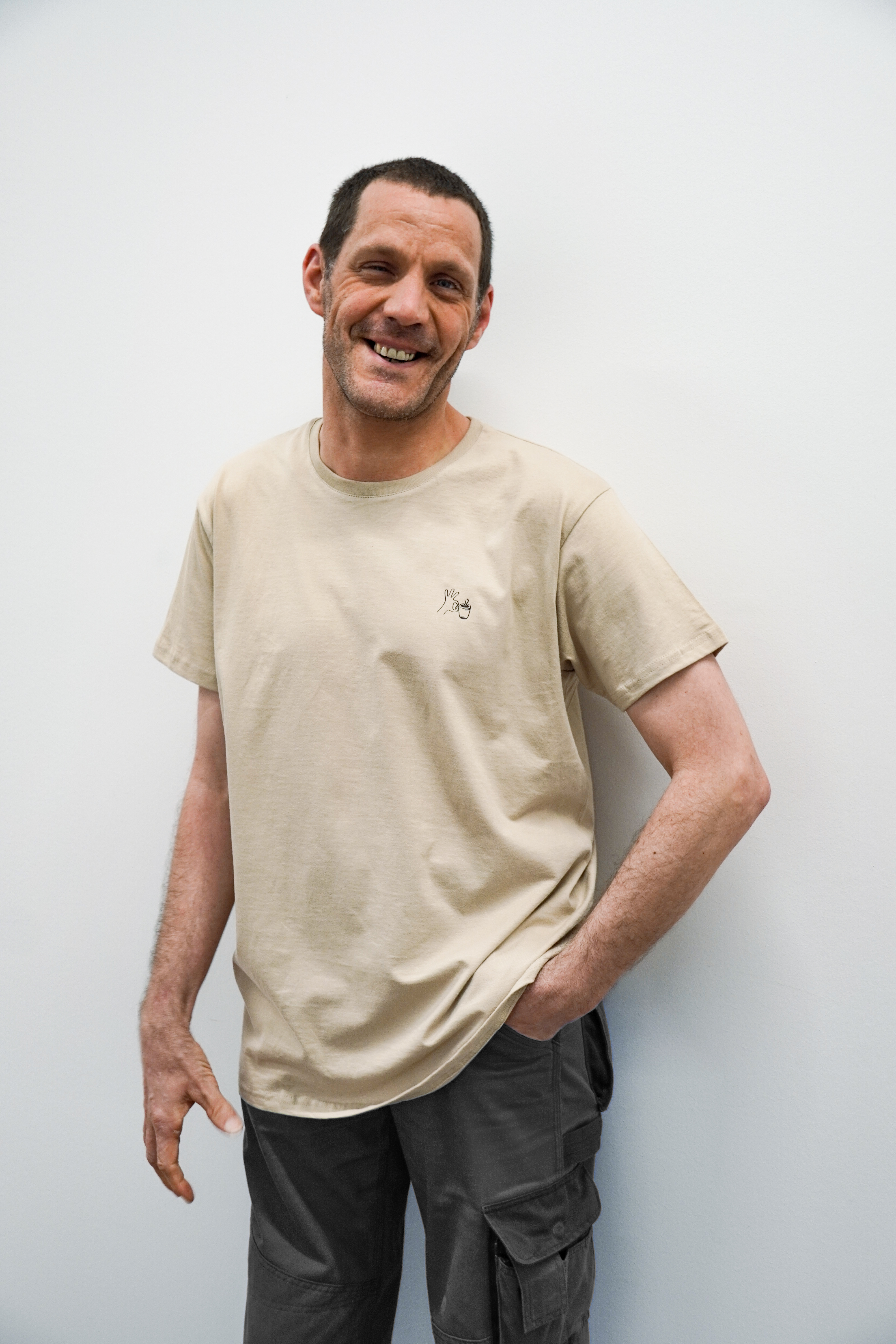 Foto von Mann mit Westpfalzrösterei T-Shirt beige mit Kaffeetasse in Hand Aufdruck
