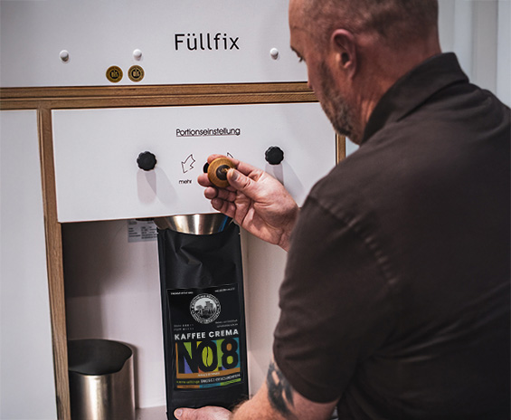 Foto von Mitarbeiter, der Kaffee in die Tüte abfüllt